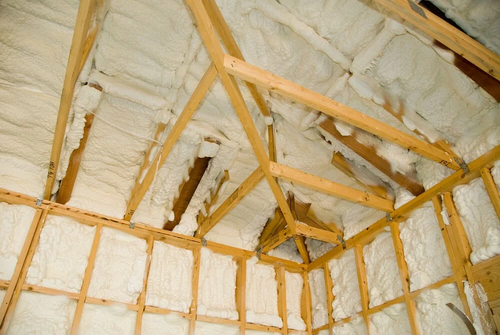 Spray foam insulation applied between timber rafters in a loft